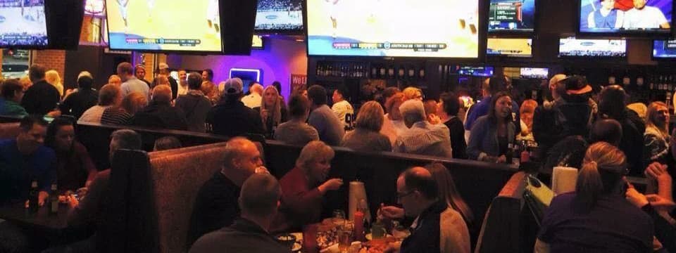 Interior bar crowd with TVs showing sports