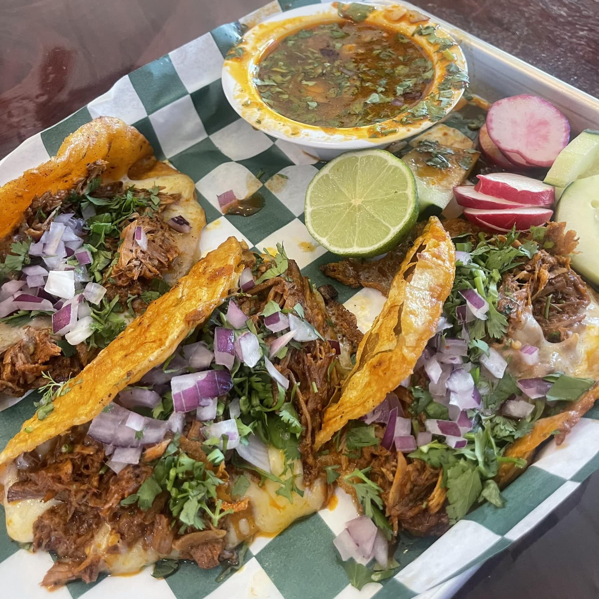 Assorted tacos with consomme, lime, radish, cucumber