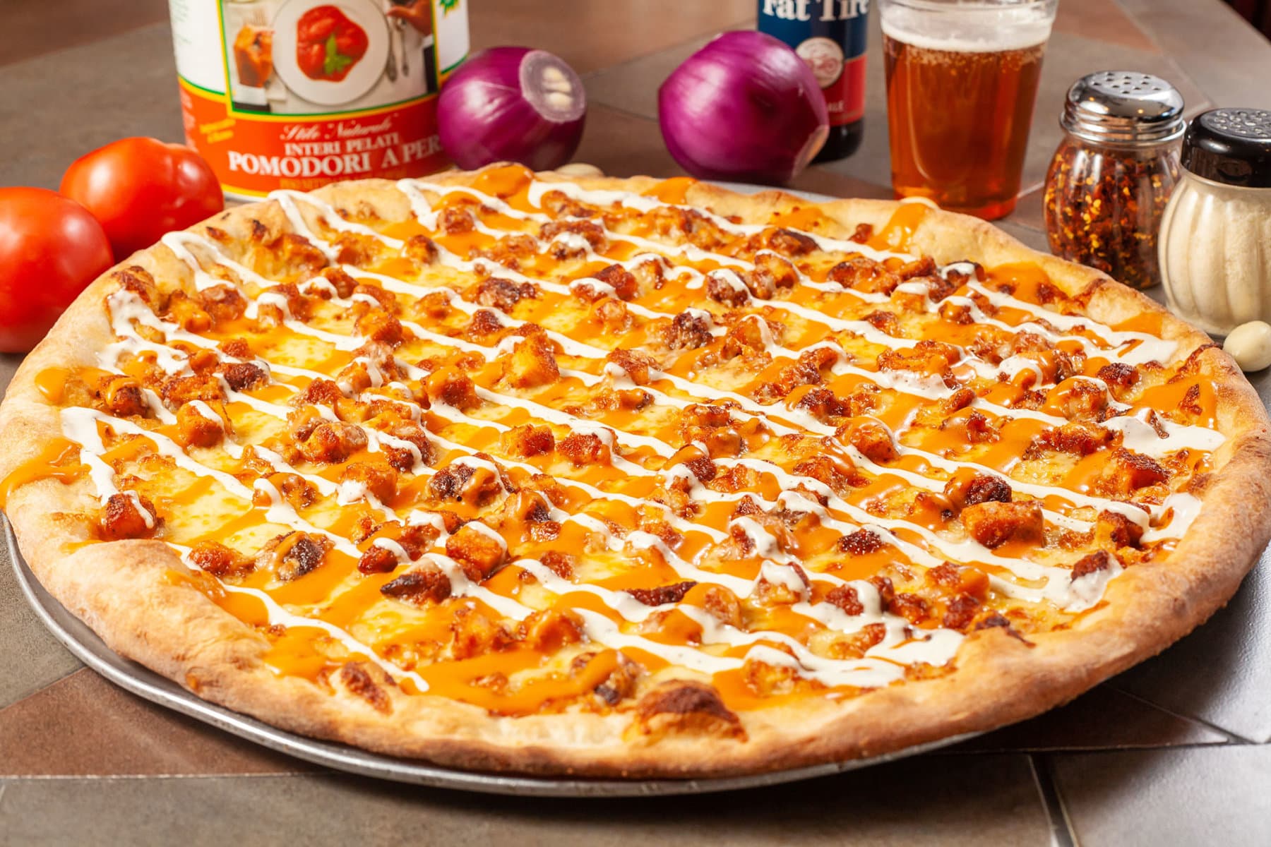 Buffalo chicken pizza on table with props