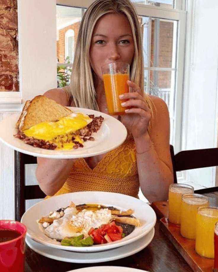 Woman holding brunch plates with omelet and juice