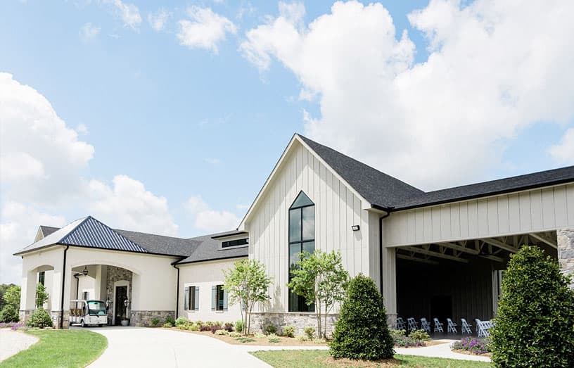 Exterior of white farmhouse-style wedding venue building