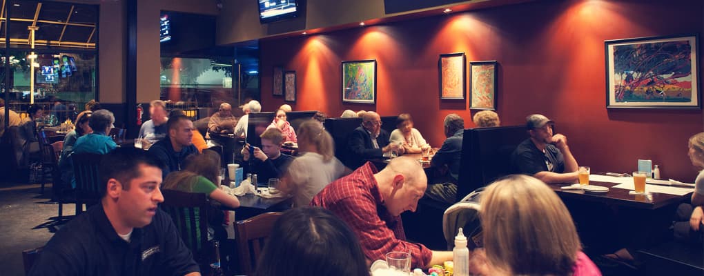 Restaurant dining room with patrons and wall art