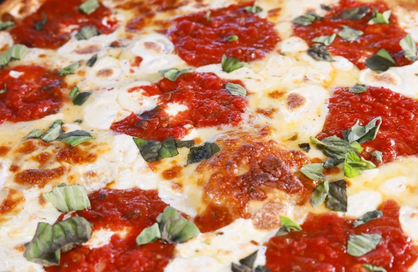 Pizza being placed into a commercial pizza oven