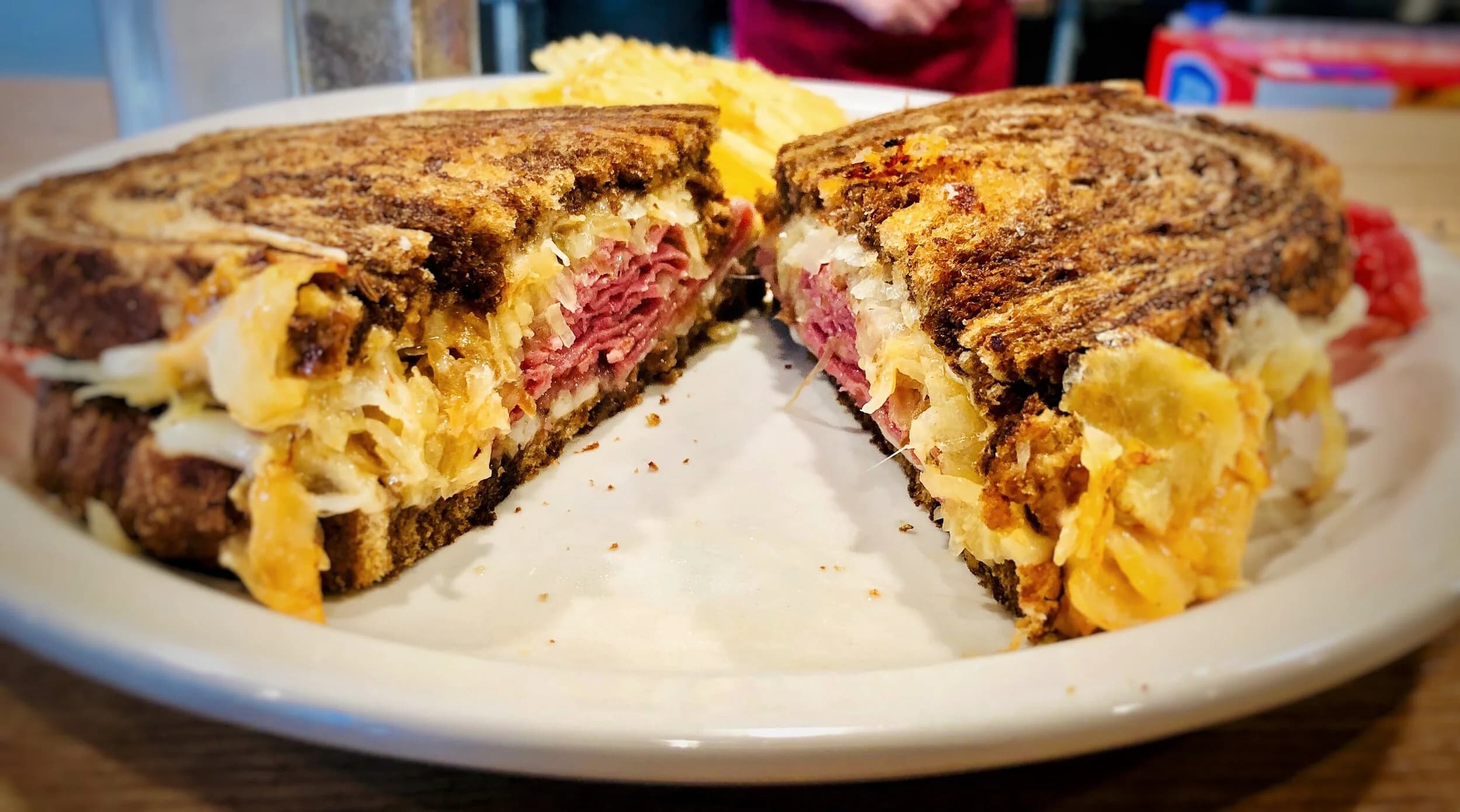 Reuben sandwich sliced in half with chips