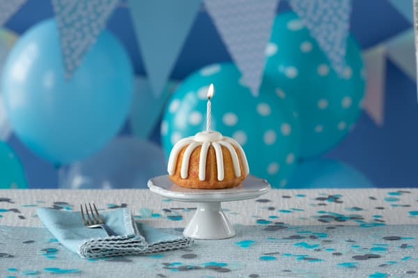 Bundt cake with candle on birthday party stand