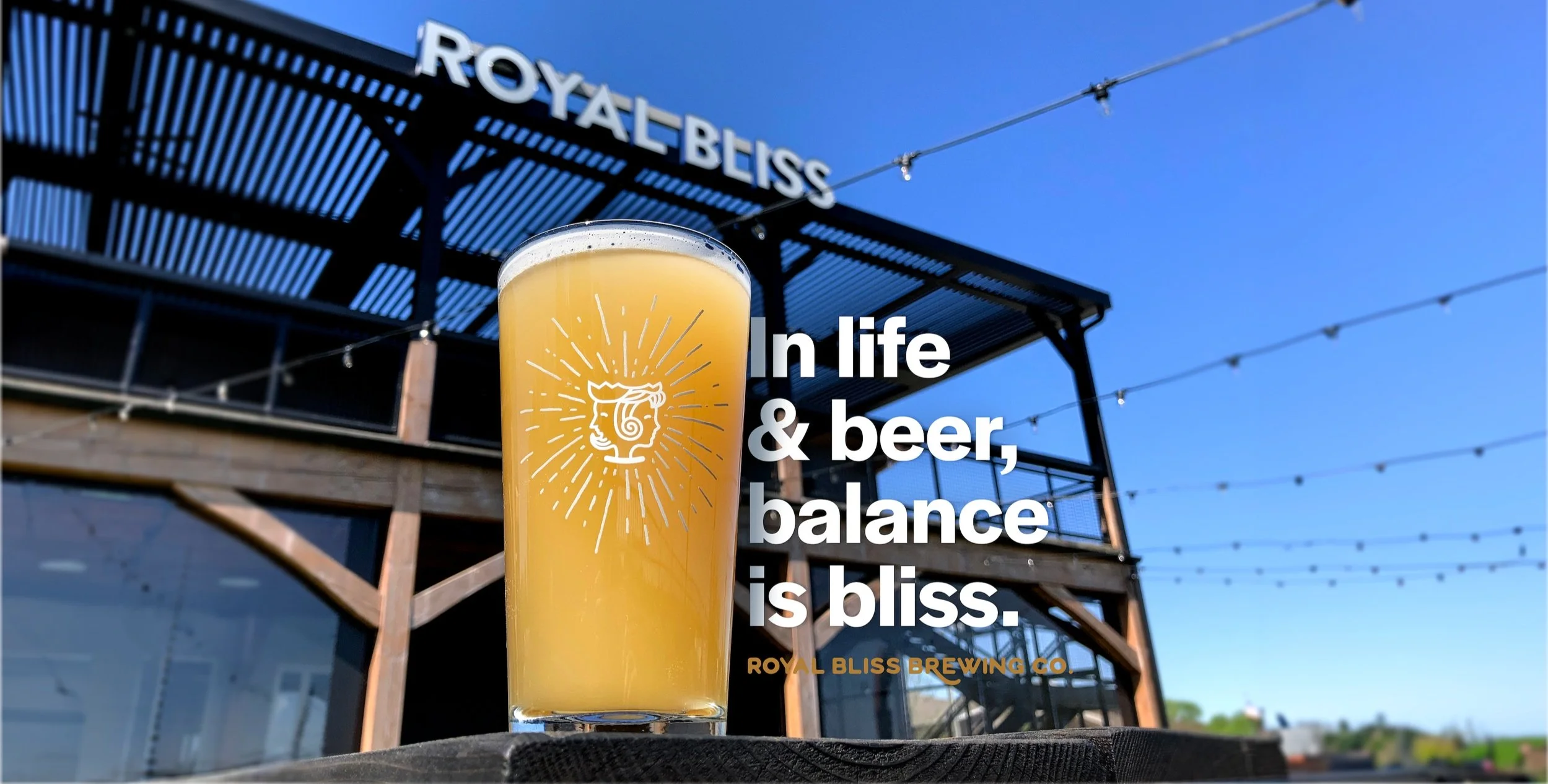 Beer glass with brewery building and sign in background