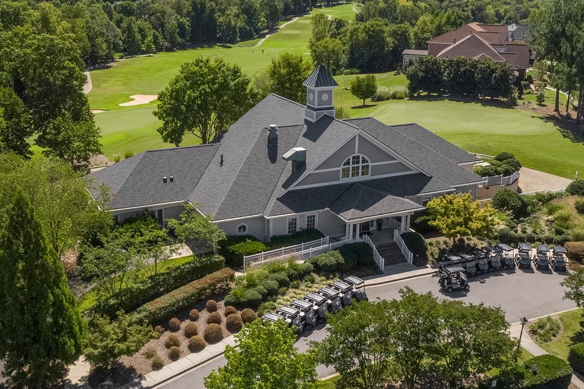 Aerial view of golf clubhouse building with cart lineup