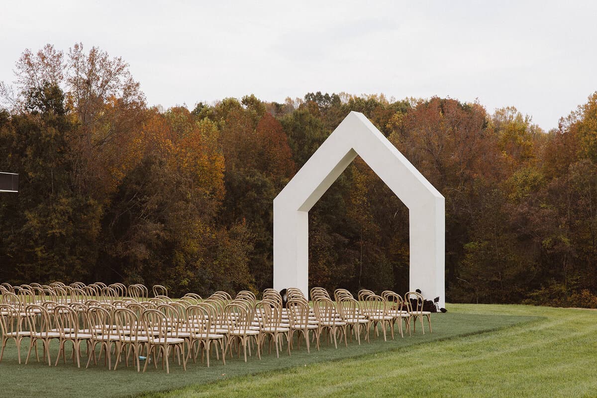 Outdoor ceremony arch with rows of chairs on lawn