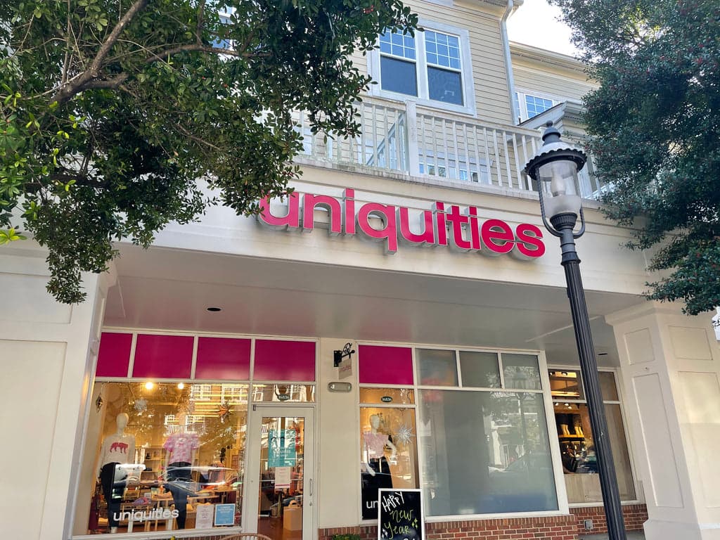 Storefront with Uniquities sign and window displays