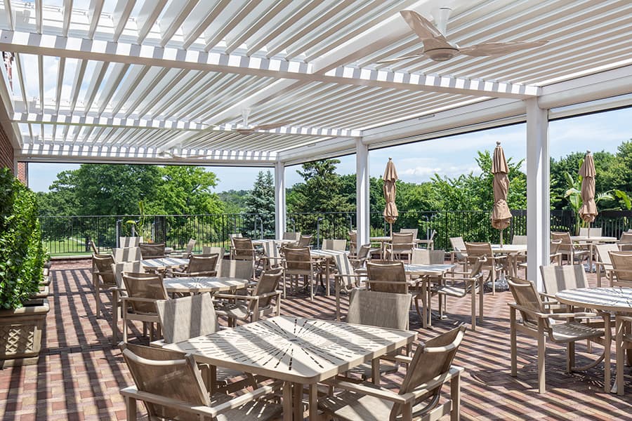 Large covered patio with dining furniture and views