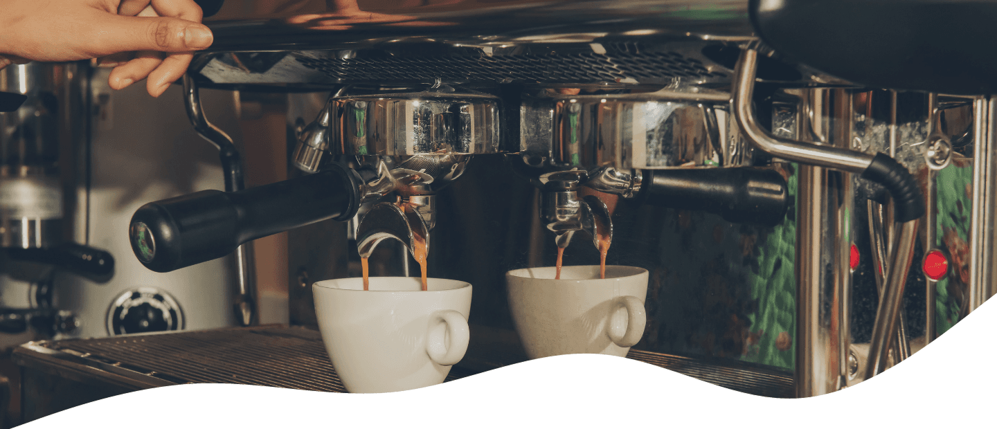 Espresso machine pouring coffee into cups