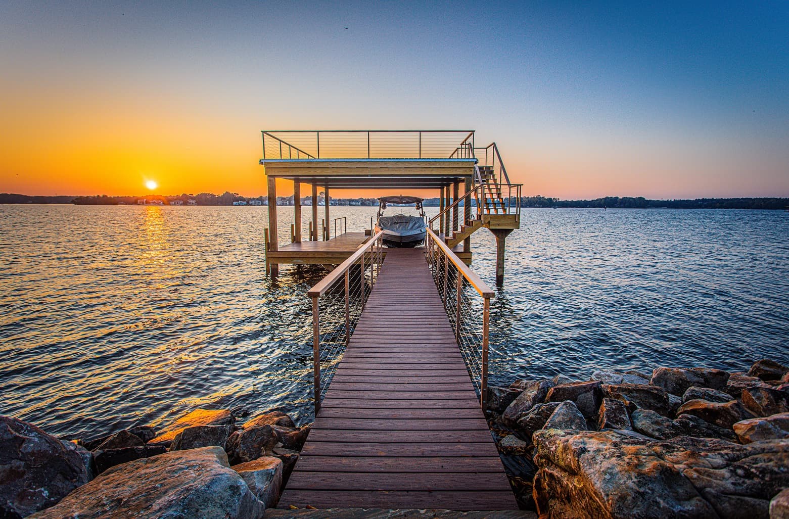 Wooden dock at sunset with boat and structure