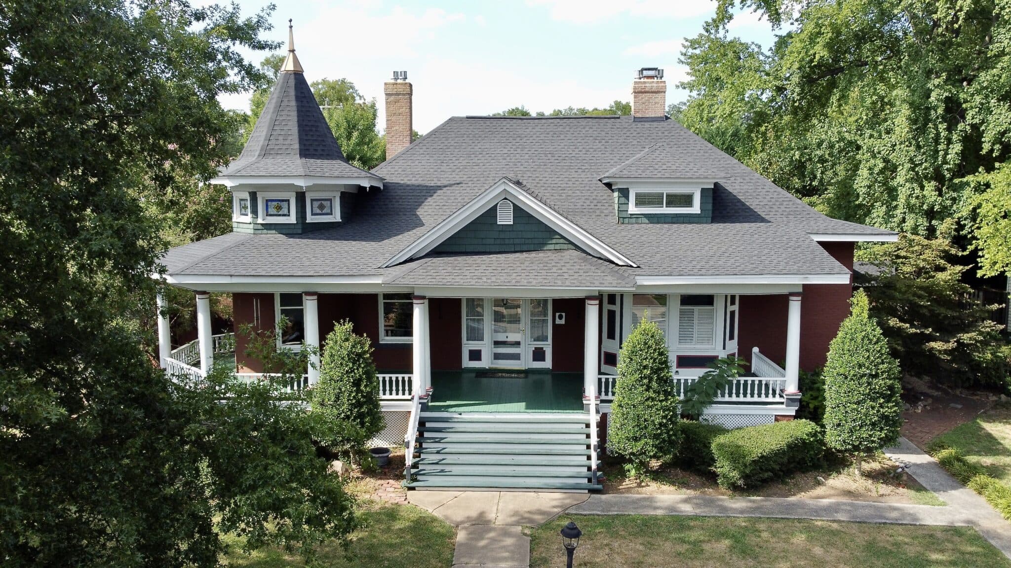 House with gray shingle roof and brick exterior