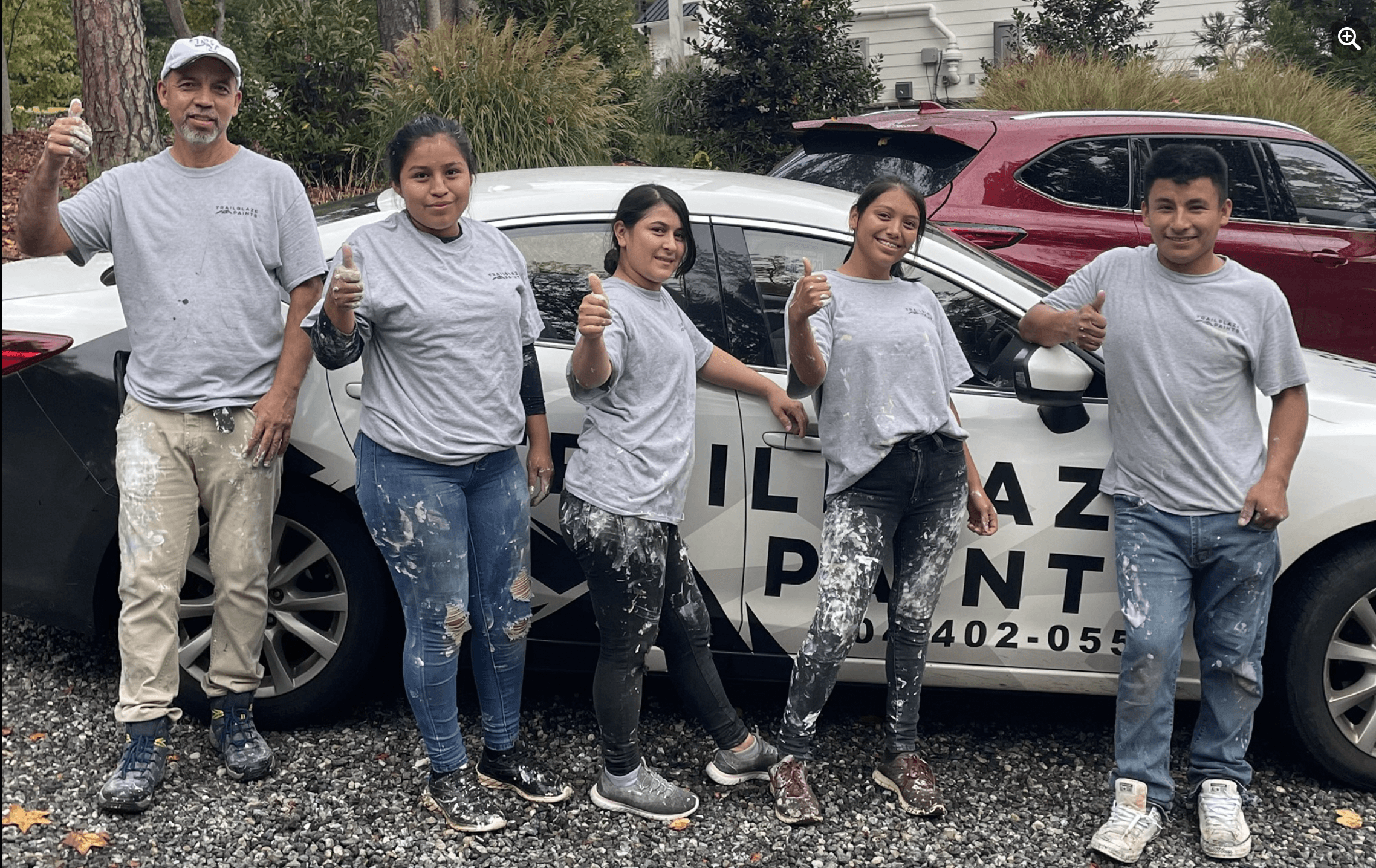 Painting crew posing with work vehicle