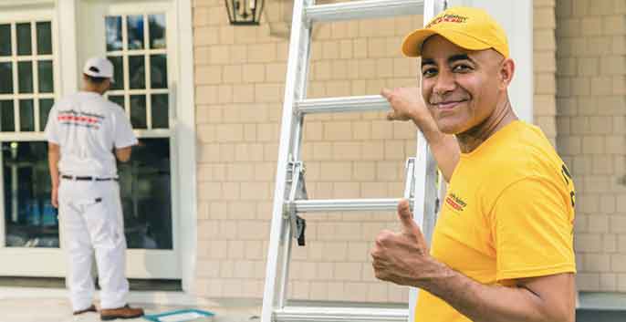 Painter in yellow shirt with ladder