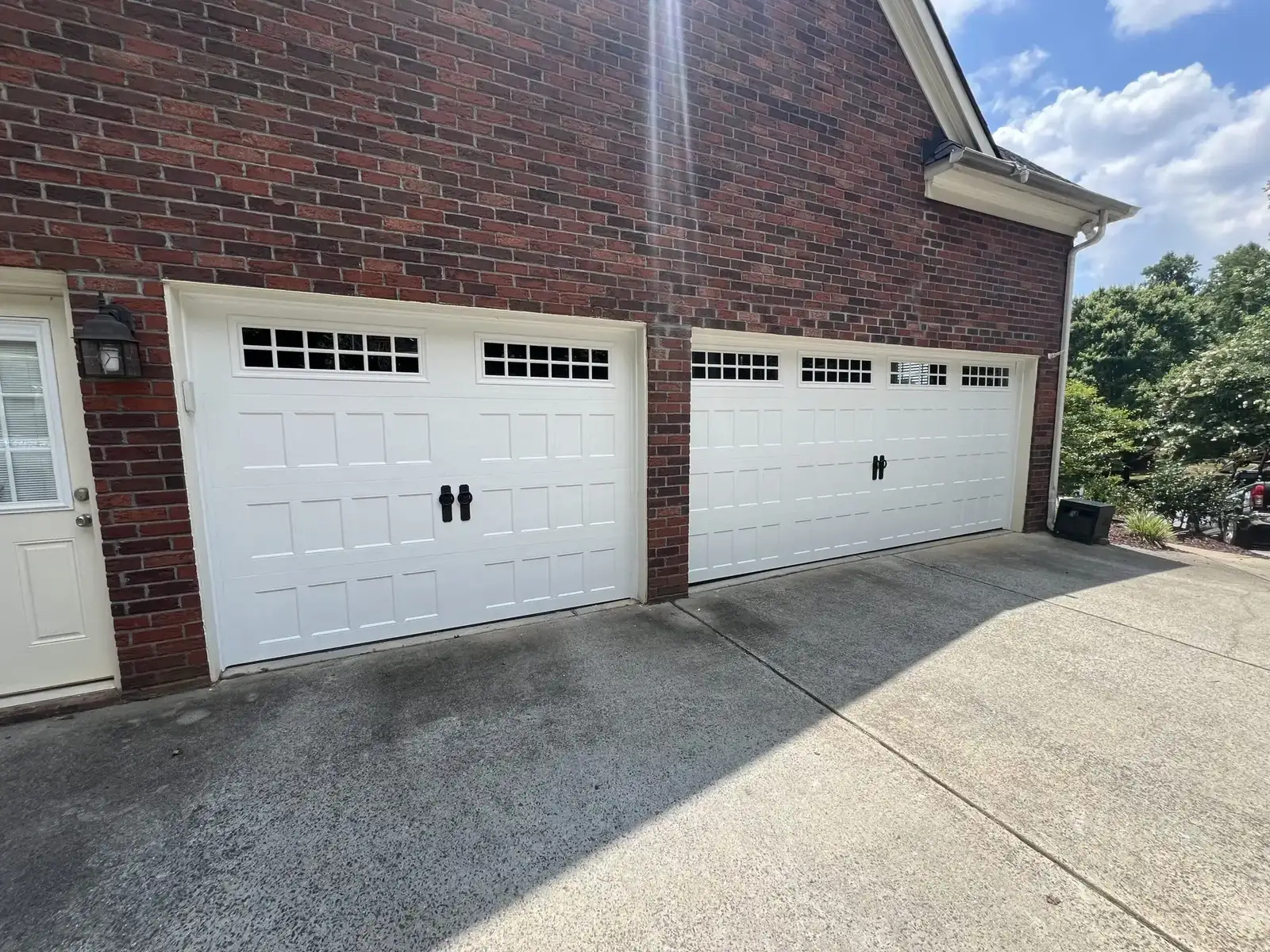 Two white garage doors on brick house