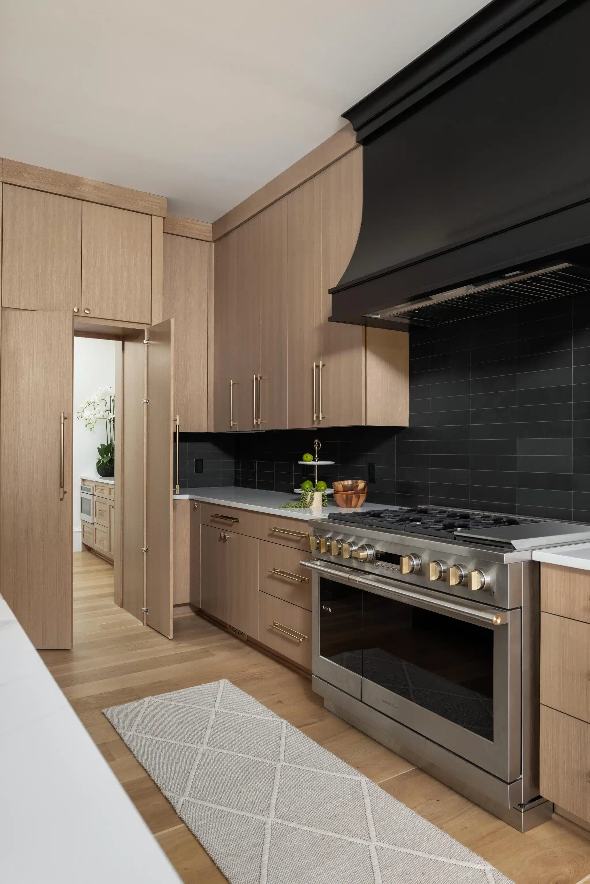 Modern kitchen with wood cabinets and black tile