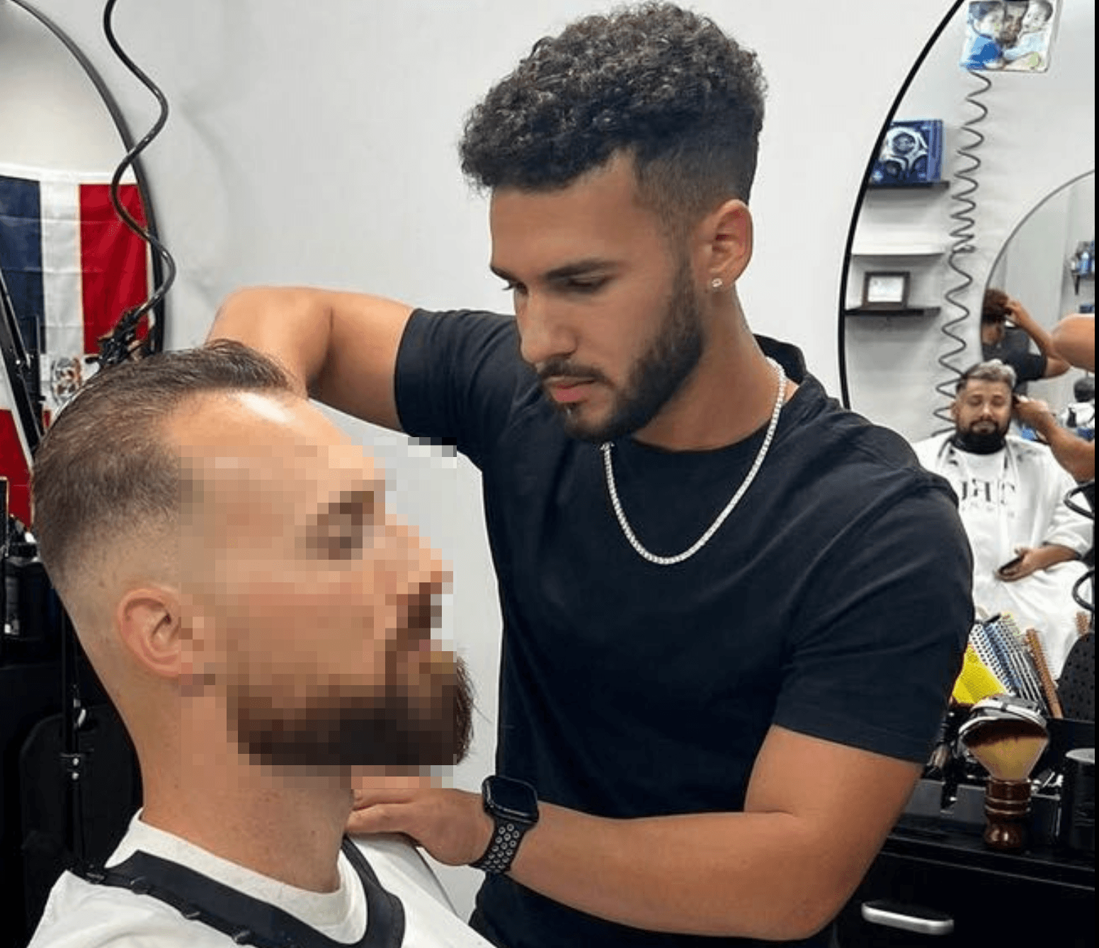 Barber cutting client's hair in salon
