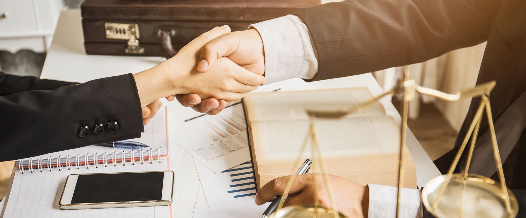 Lawyers shaking hands over legal documents
