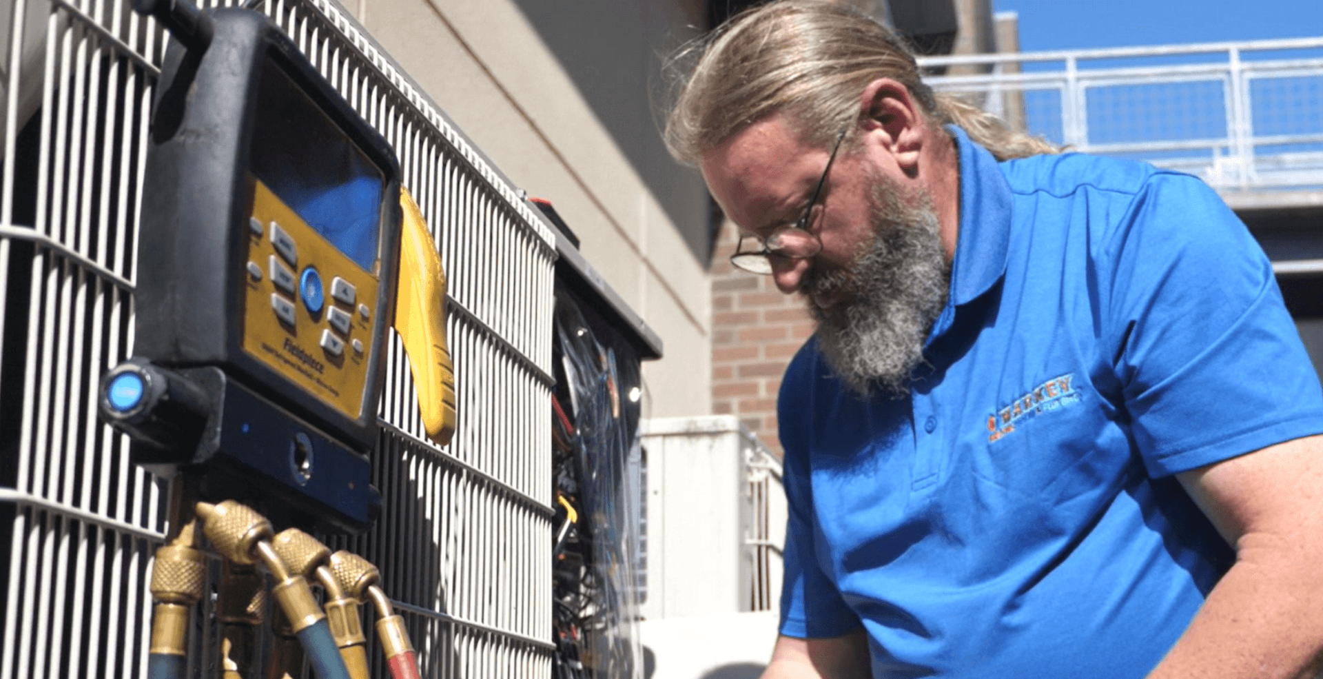 Technician inspecting HVAC outdoor unit