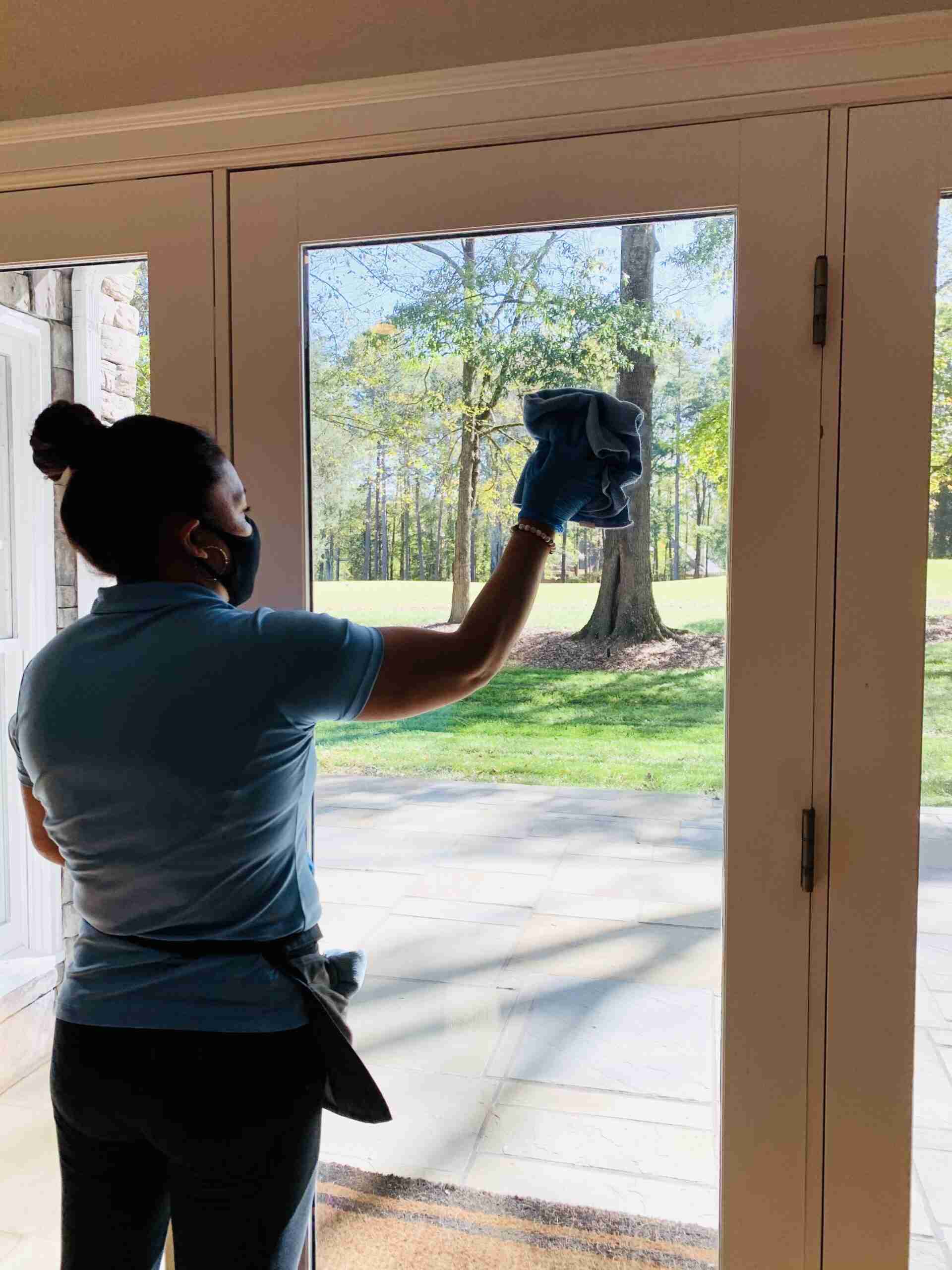 Woman cleaning glass doors with cloth
