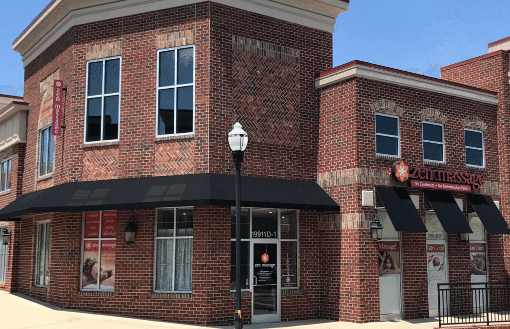 Brick storefront with black awning and signage