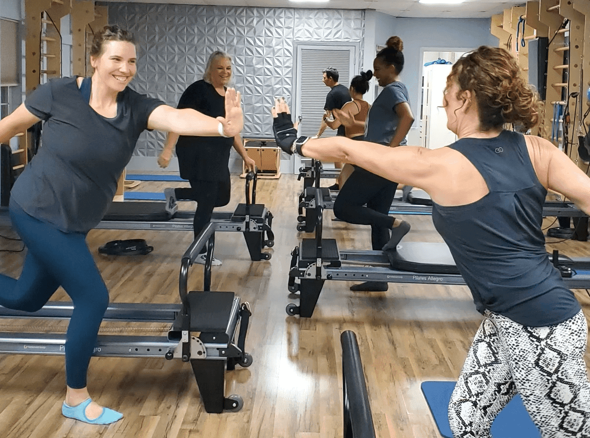 Pilates class in session with reformer machines