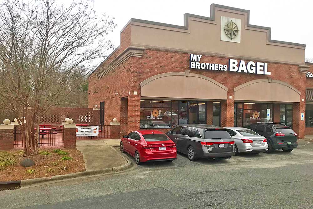Storefront exterior with signage and parking