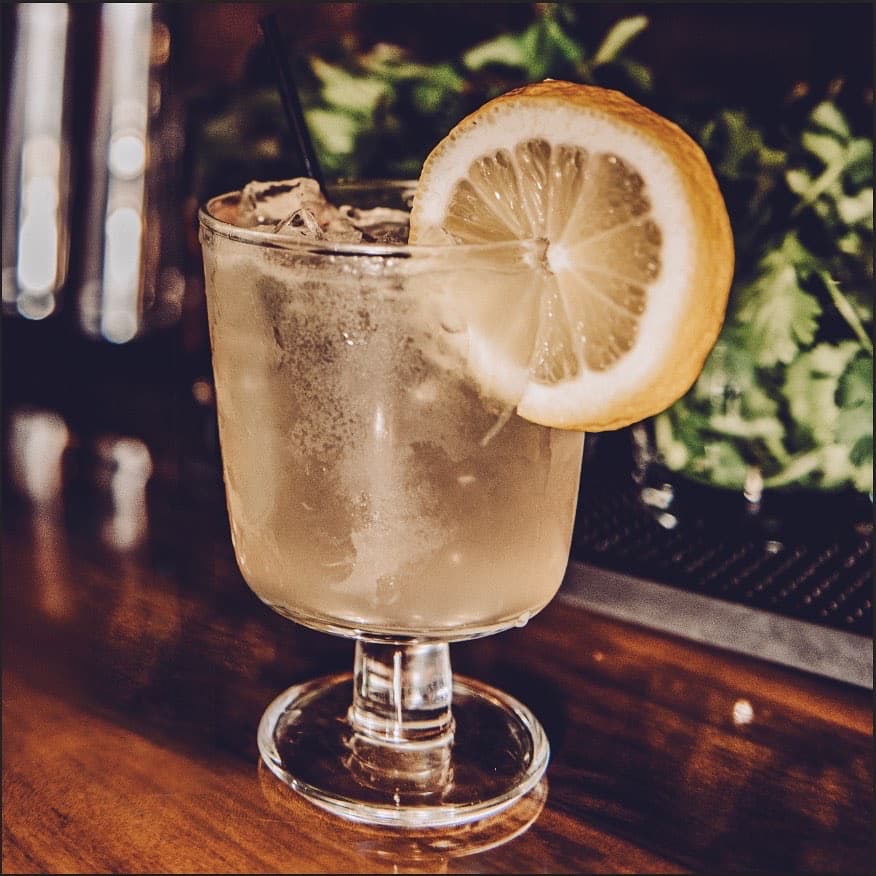 Cocktail with lemon garnish at bar