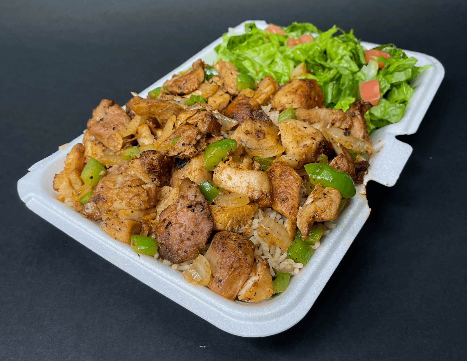 Chicken over rice with vegetables and salad
