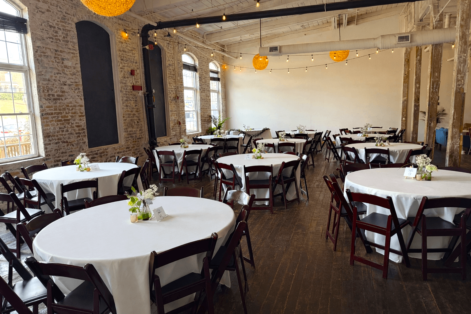 Event space with round tables and brick walls
