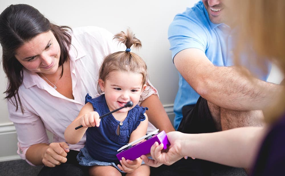 Teacher with children using musical instrument