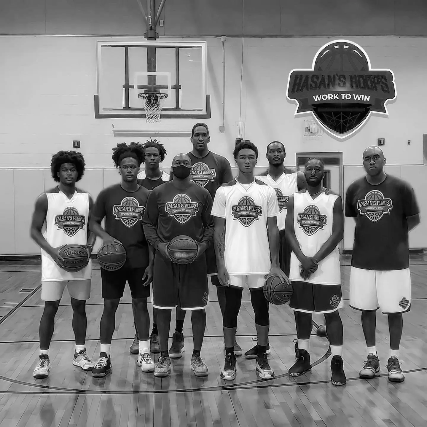 Basketball team posing in indoor gym facility