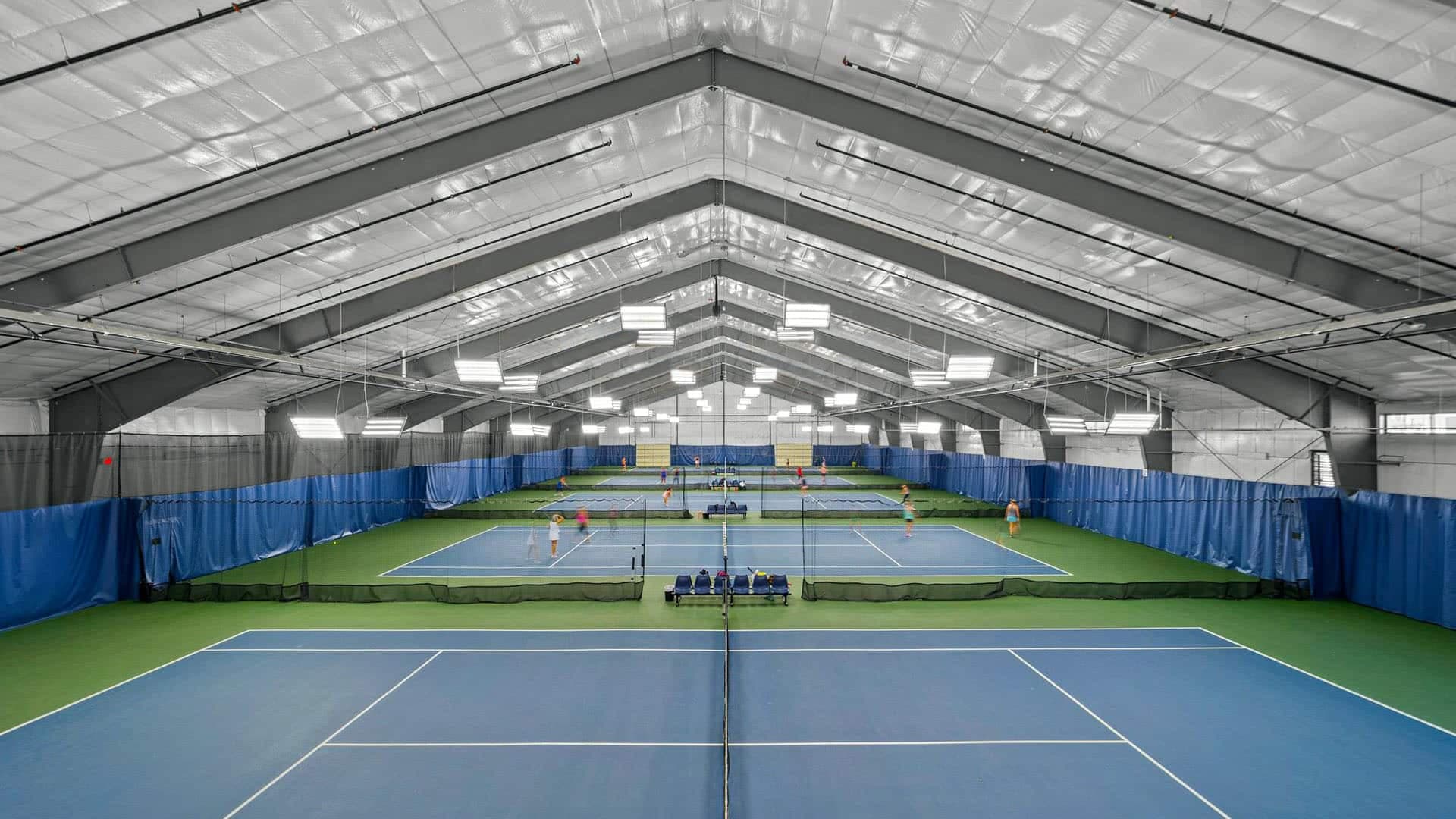 Indoor tennis courts with blue and green surfaces