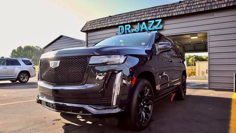 Black SUV at Dr. Jazz storefront building