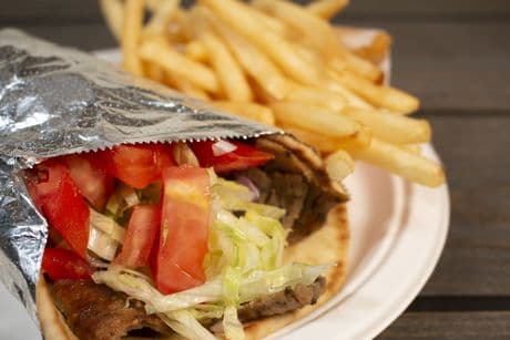 Gyro wrap with fries and coleslaw on plate