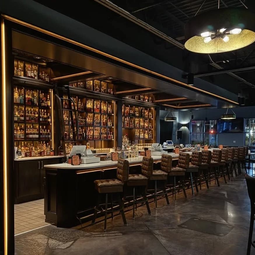 Bar interior with shelves of liquor bottles and seating