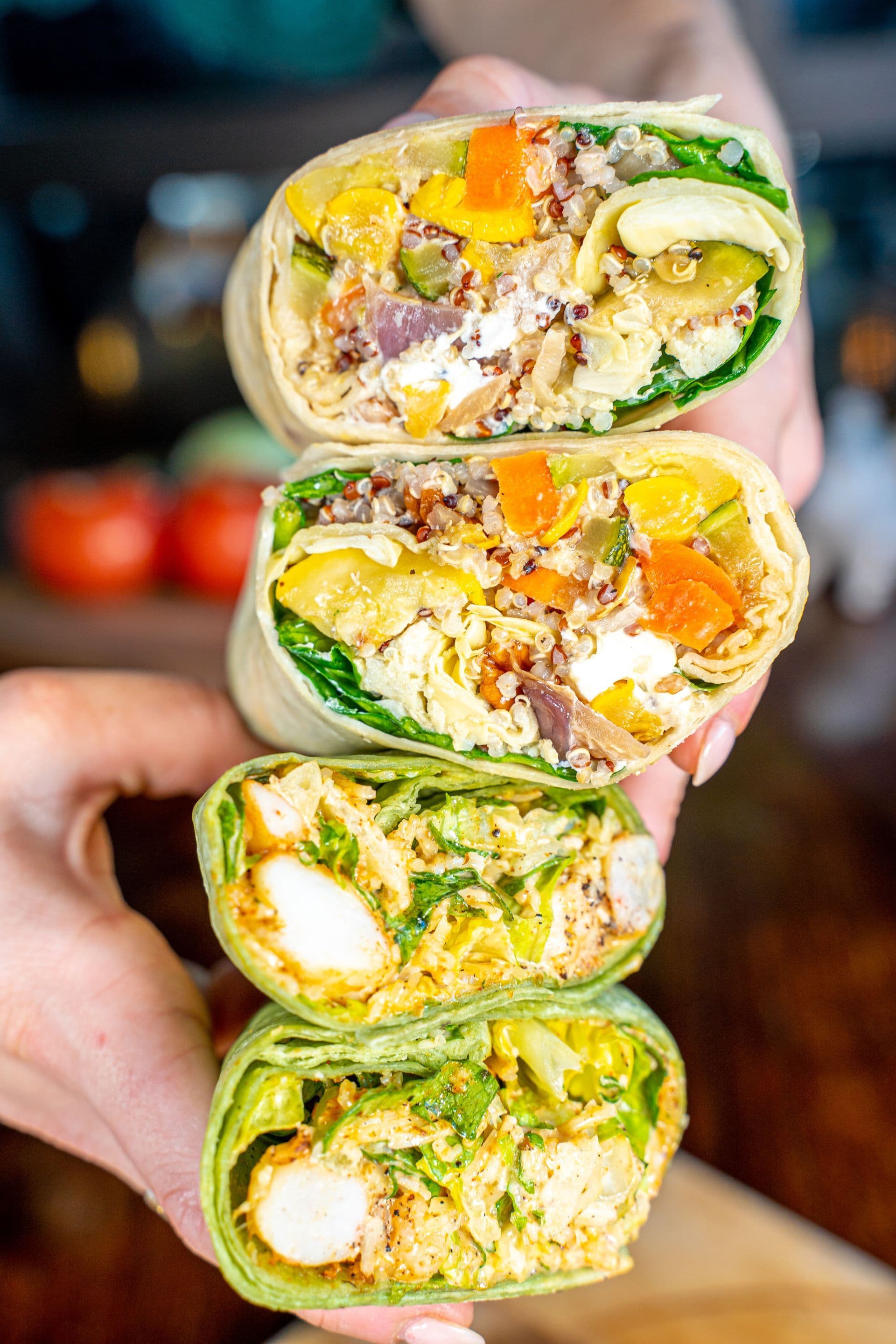 Wraps cut in half showing colorful vegetable and chicken fillings