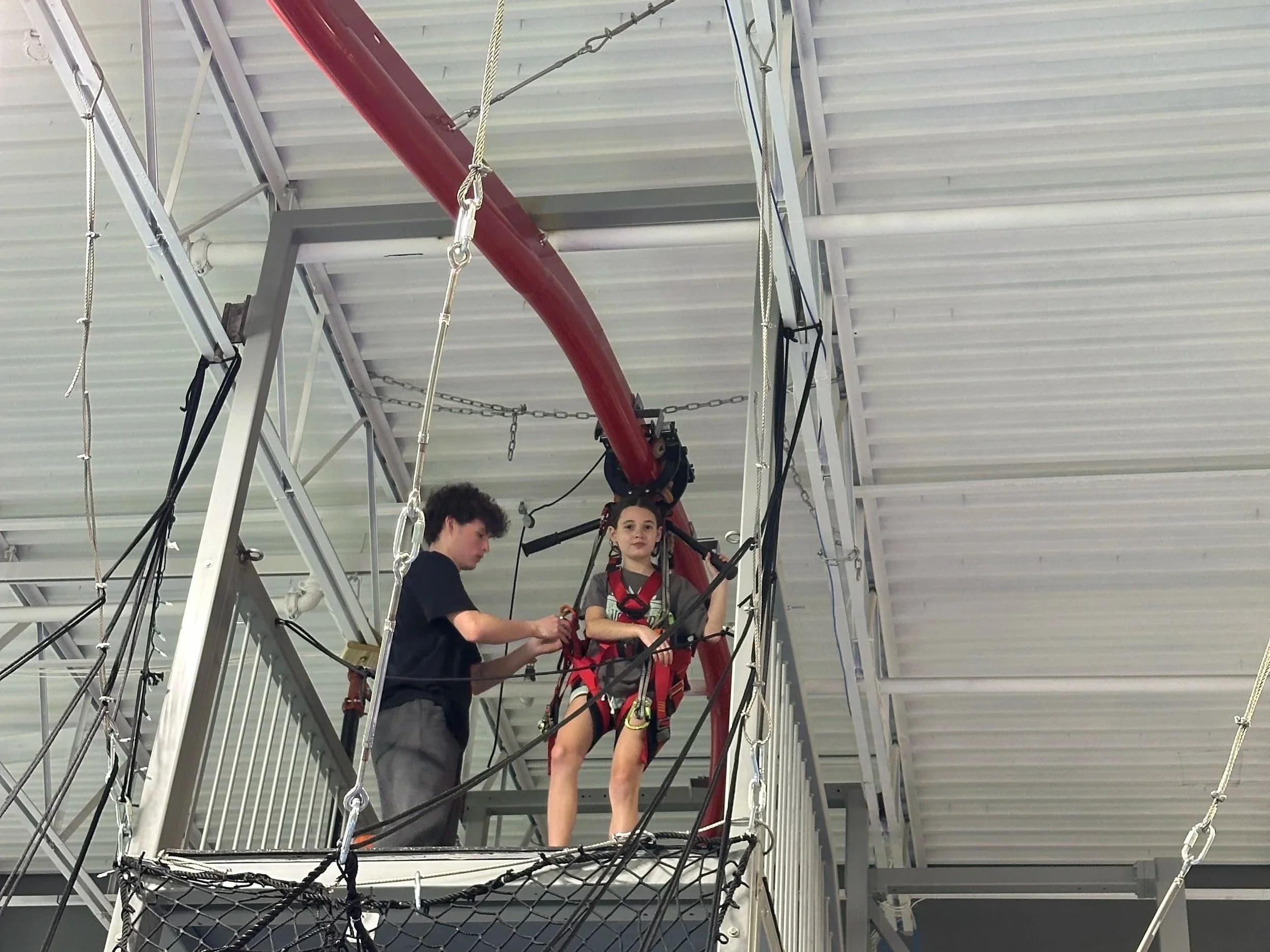 Kids harnessed on high ropes course platform