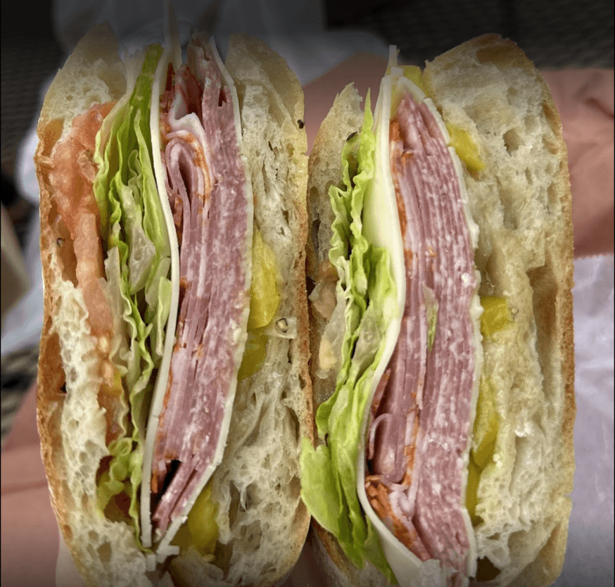 Sliced Italian sub sandwich with meats, cheese, lettuce