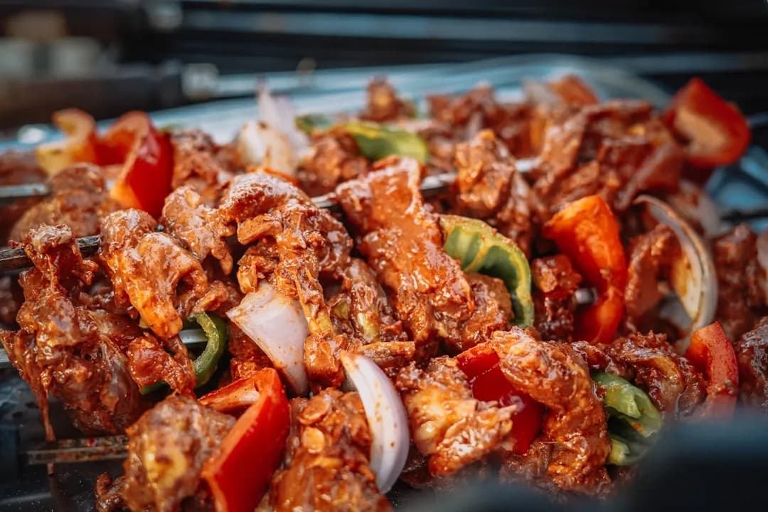 Skewered meat and vegetables grilling on skewers