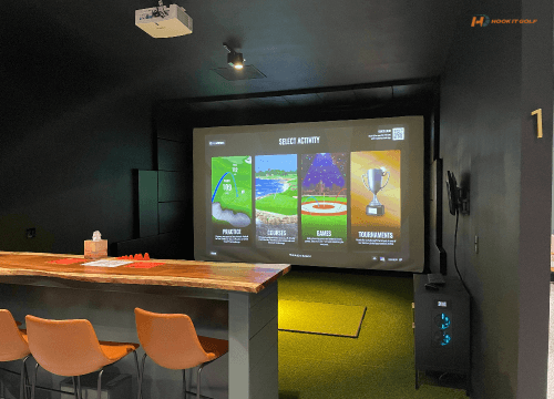 Golf simulator room with bar seating and screen
