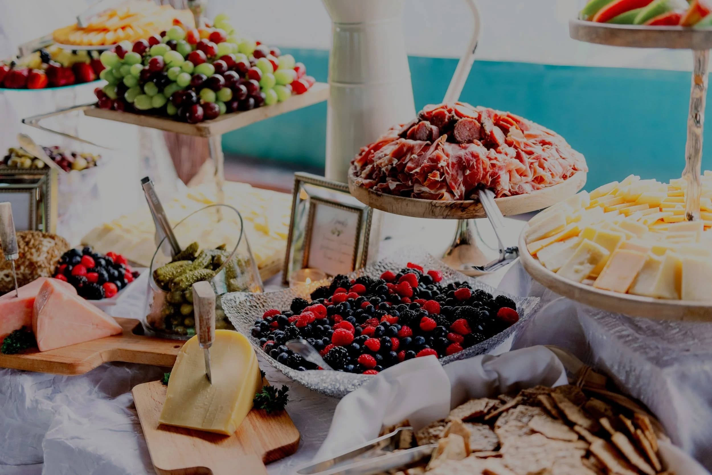 Spread of catered food including meats, cheeses, fruits