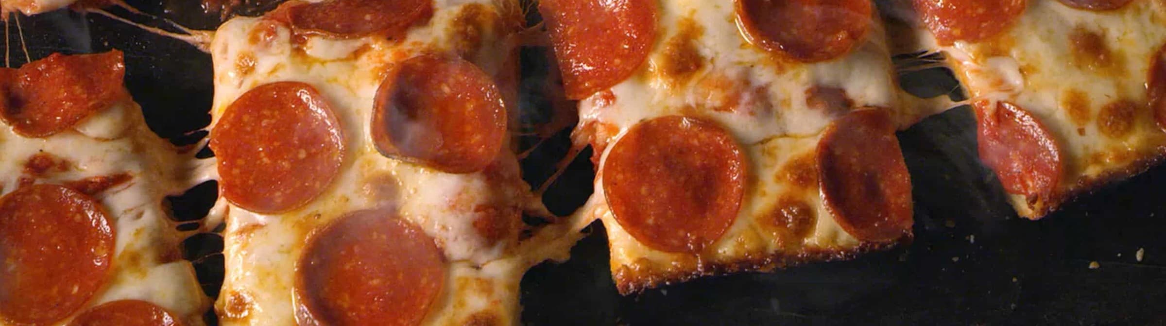 Close-up of pepperoni pizza slices with melted cheese