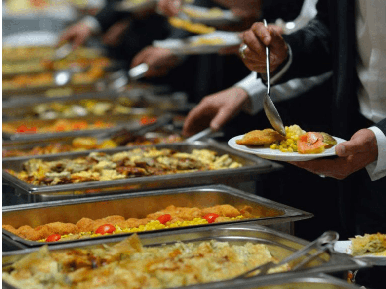 Buffet catering spread with chafing dishes and plates