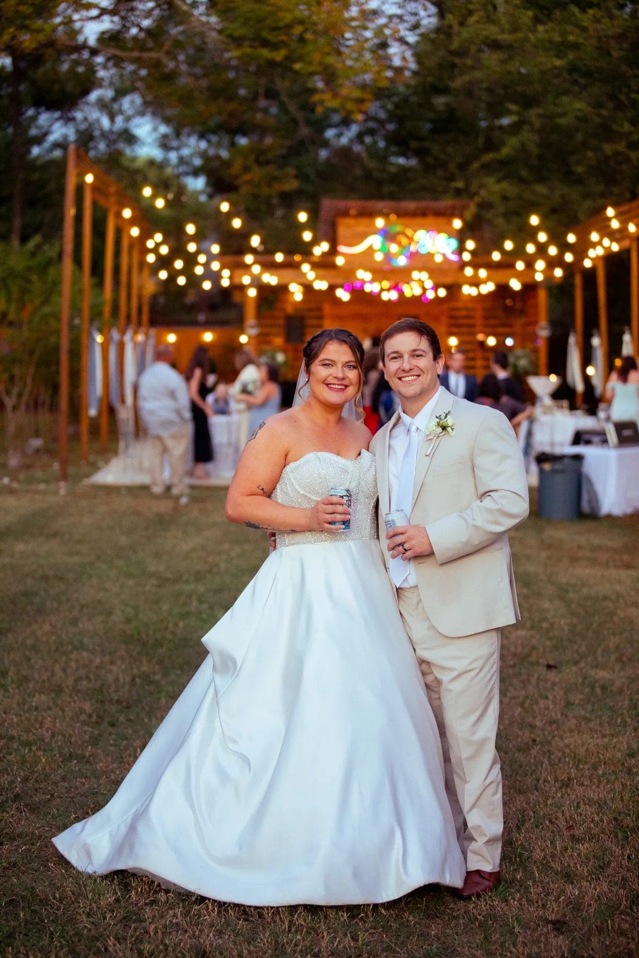 Couple at outdoor reception with string lights and venue