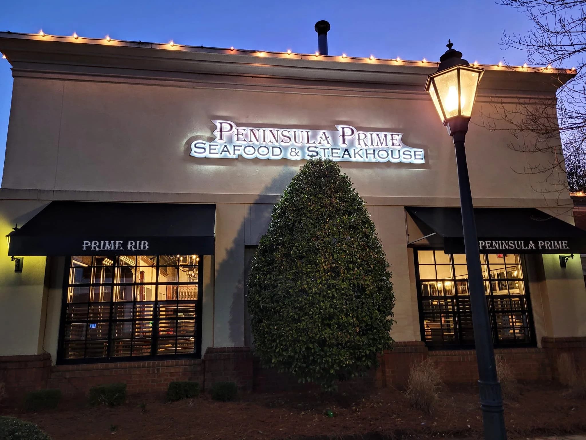 Storefront exterior with Peninsula Prime sign and lamppost