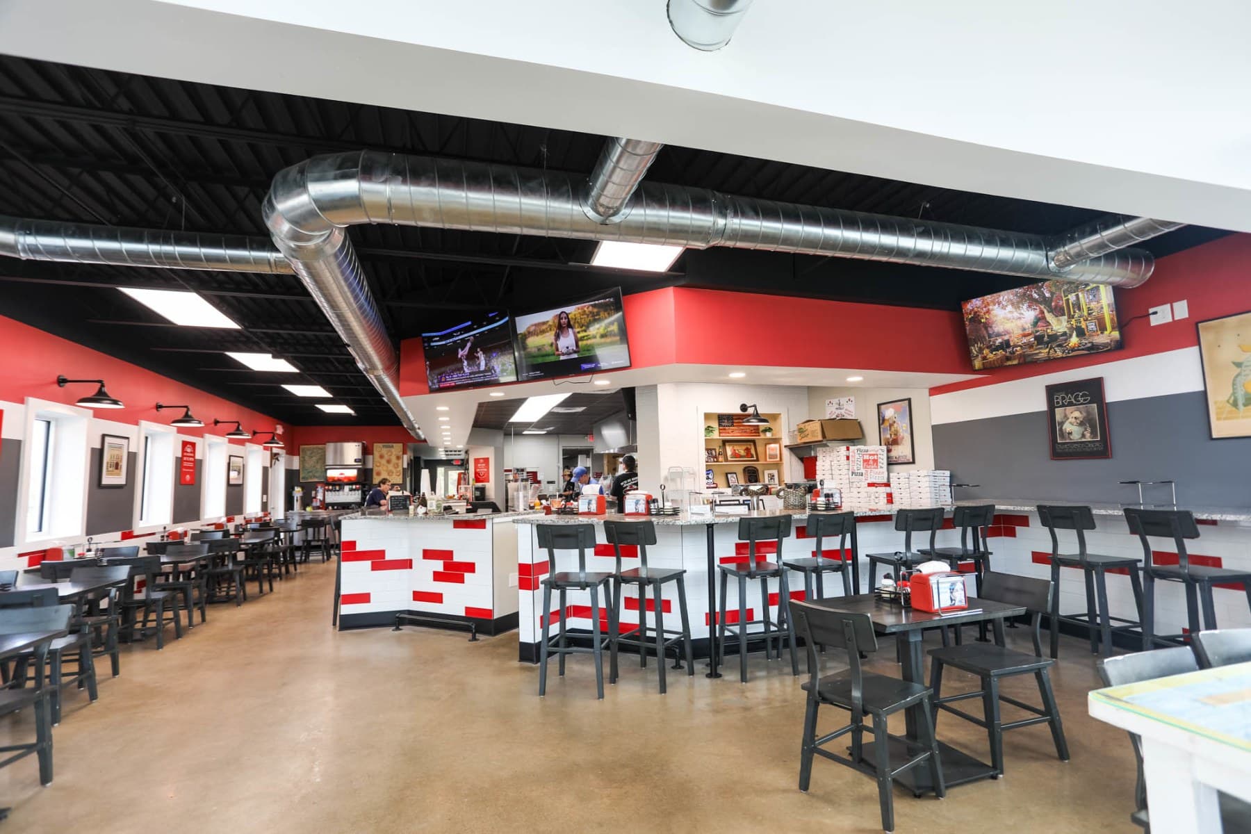 Restaurant interior with dining tables, bar and TVs