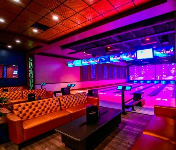 Bowling lanes with lounge seating and neon lighting