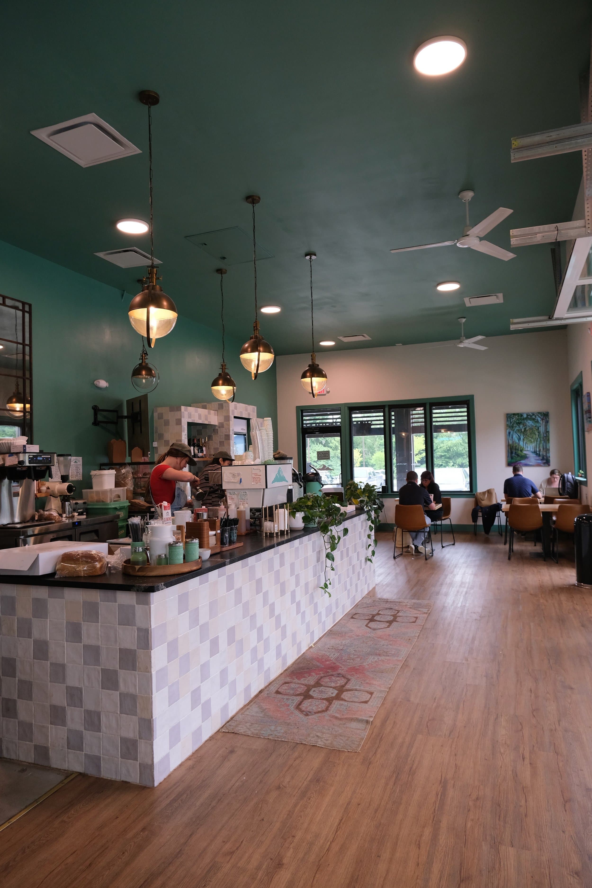 Coffee shop interior with counter, seating, and customers